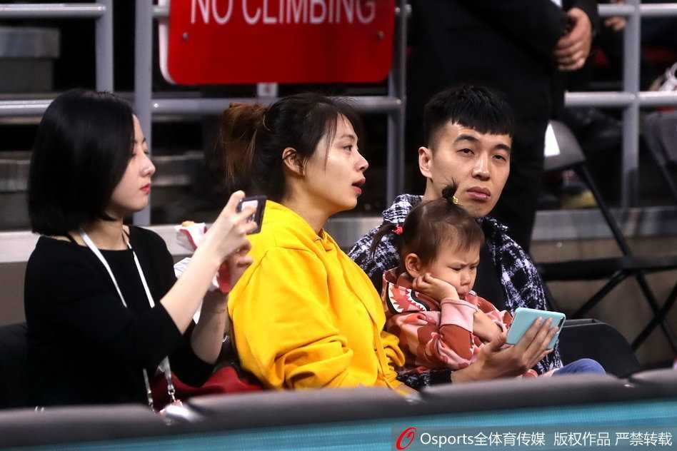 曾令旭侧身倾听友人交谈，脸上带着轻松的微笑，似乎对场上的高强度对抗并不感到意外。