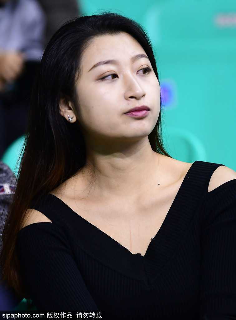 这位“彩虹女神”正低头摆弄着手机，似乎想要记录下今晚在球场的奇妙经历，她的发辫如瀑布般垂下，成为本溪体育馆那个赛季最柔和的回忆。