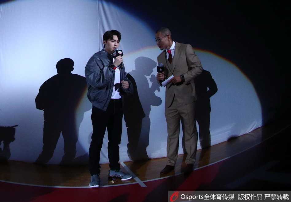 李易峰在场边与明星球员热聊，眼神专注仿佛在探讨球场战术，展现资深球迷本色