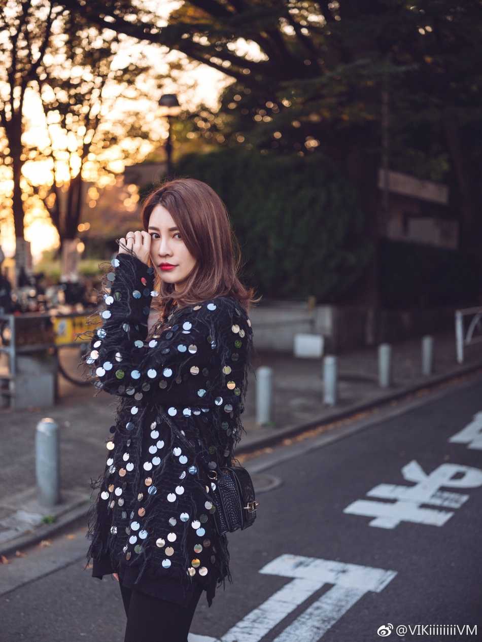 李根妻子王星洋身穿浅色时尚针织衫，在暖阳下微笑，显得温婉动人，尽显温柔气质。