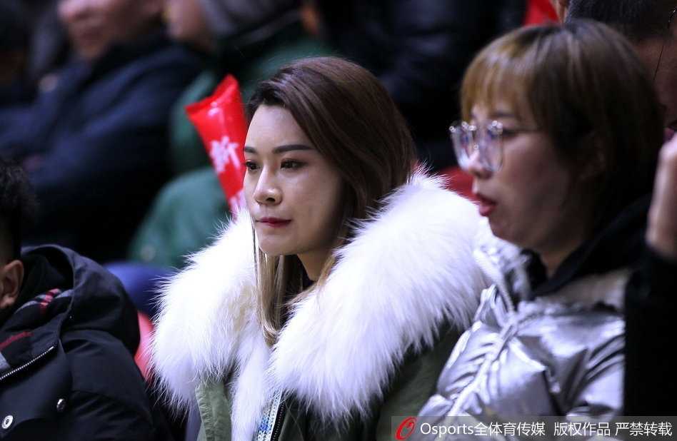 李根妻子王星洋神情专注地坐在新疆主场看台上，眼神中充满对丈夫复出之战的期待与支持