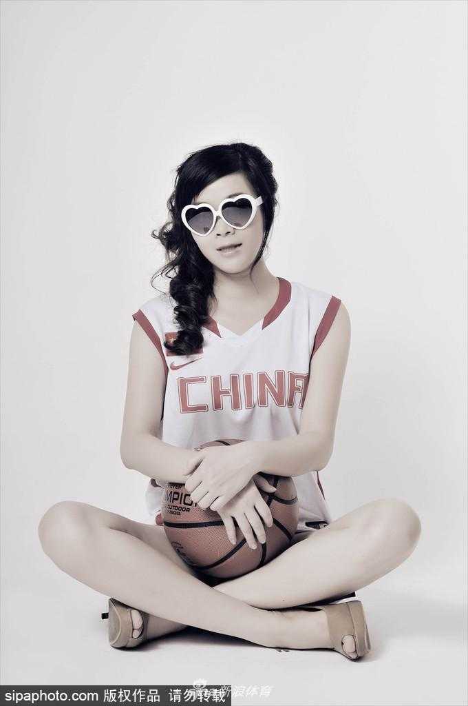 李怡将男篮战袍当作时尚单品，随性地撩动秀发，露出修长美腿，心形眼镜下是自信而迷人的微笑。
