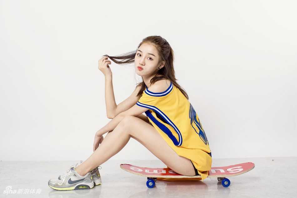 江慧抱着滑板坐在台阶上，歪着头露出俏皮的笑容，纤细的小腿随意搭着，可爱又随性