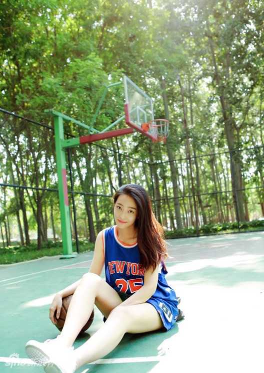 泳池边的傲娇比心:邻家女孩王艺诺的复古休闲时光 复古风格的泳池边,王艺诺身着休闲球衣,微微侧身看向镜头,神情中带着一丝傲娇与挑衅,仿佛在说“来呀,看什么呢?”,整体氛围轻松又俏皮。