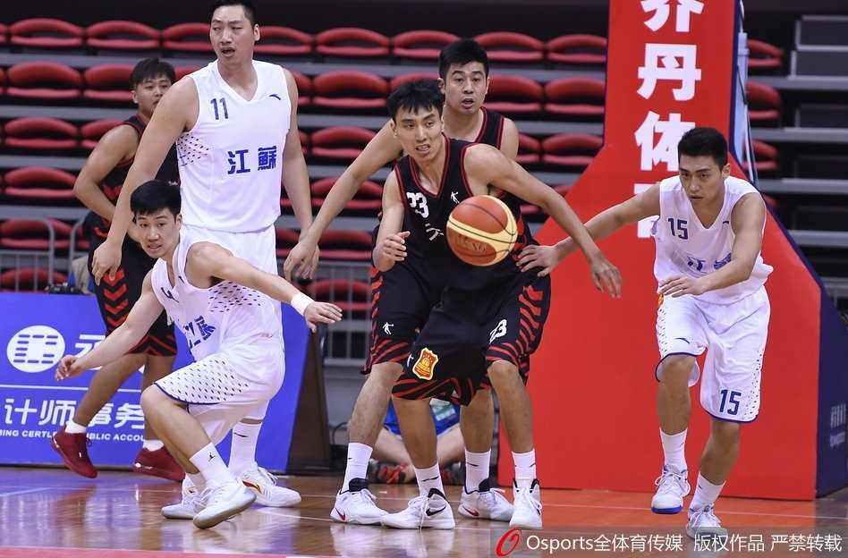 易立在防守球员的围堵下依然冷静地将球传给队友，眼神中透露出必胜的信念。