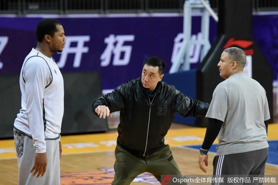 津门故人聚 篮球情缘新 训练结束后,休利与王非在场边促膝长谈,两人面带笑容,身后的球馆灯光映照着这份深厚的篮球情谊。