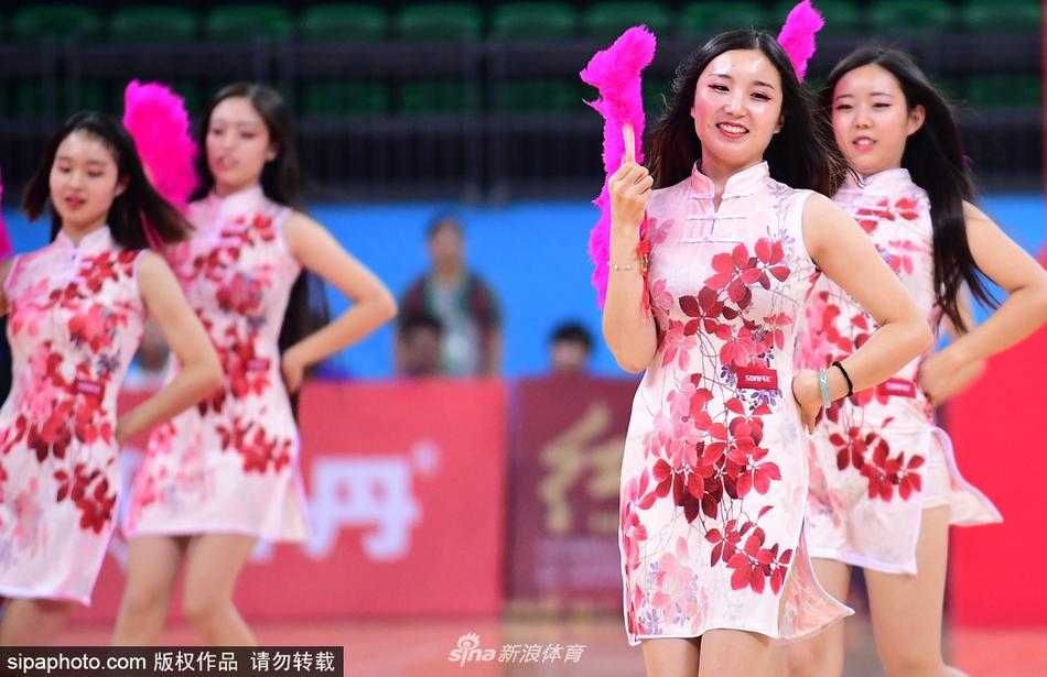 津门旗袍宝贝舞动全运赛场 篮球架起传统文化与体育桥梁 一名旗袍宝贝正做出一个托举动作,她身上的旗袍绣着精致的盘扣,在聚光灯下丝质面料泛着柔和光泽,展现了力量与柔美的完美结合。