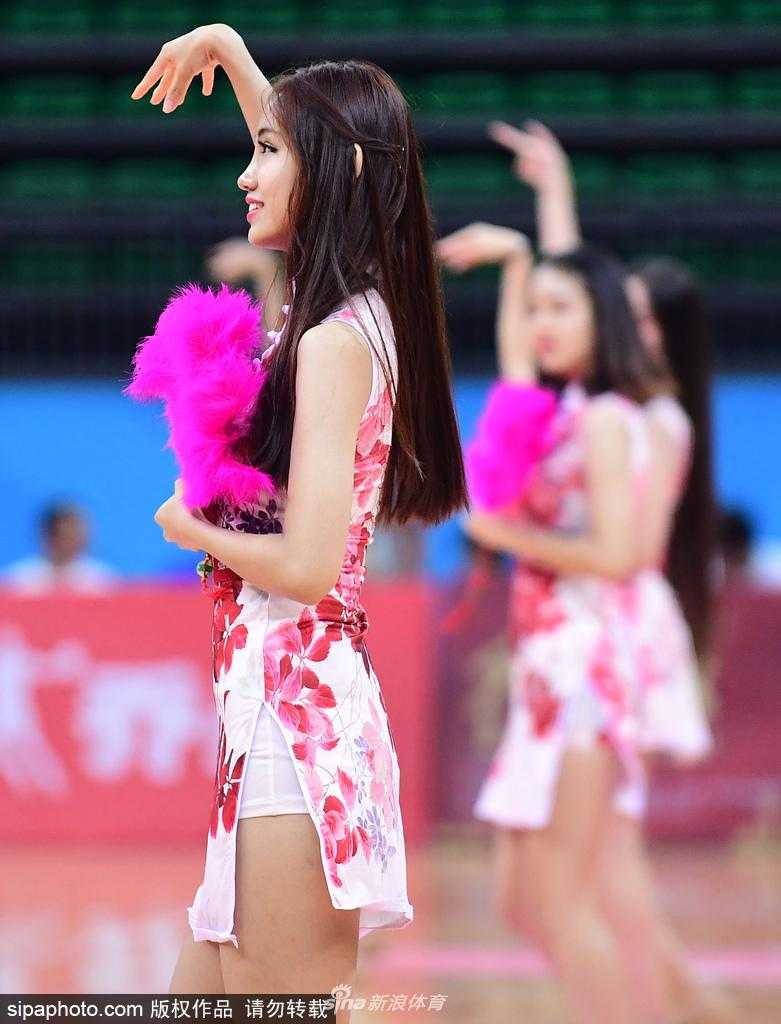 津门旗袍宝贝舞动全运赛场 篮球架起传统文化与体育桥梁 几位旗袍宝贝摆出结束造型,她们或坐或卧在球场地面上,旗袍的开衩设计巧妙地露出腿部线条,整体画面宛如一幅现代都市的仕女图。