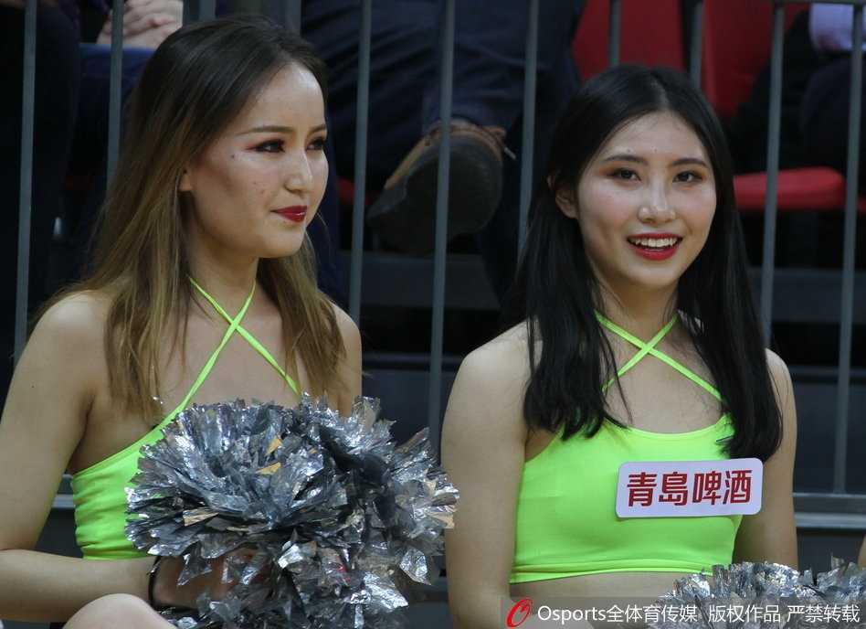 津门赛场炫舞团:篮球宝贝热力绽放,点燃津疆大战激情 在赛场璀璨的灯光下,两位篮球宝贝背靠背摆出动感造型,修长的身姿与篮球场地板上的倒影相映成趣