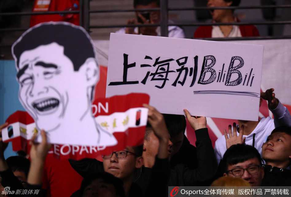 几位年轻的球迷合力展开一面巨大的蓝色旗帜，上面写着‘深圳力量’四个大字，象征着这座城市与球队并肩作战的决心。