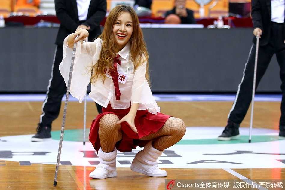 深圳篮球宝贝俏皮变装,加时赛热舞燃爆主场 近景镜头下,一名篮球宝贝对着镜头露出甜美微笑,额头上的汗珠在灯光下闪闪发亮
