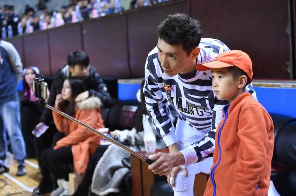 球场的绝佳观赛席位上，小轩轩在父母的陪伴下专注地观看比赛，脸上洋溢着纯真而开心的笑容，完全沉浸在篮球的快乐中。