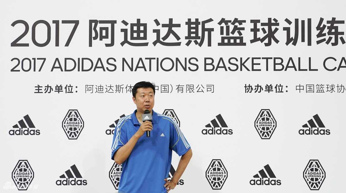 训练营的小球员们分组对抗，王治郅在场边叉腰观战，身后是醒目的阿迪达斯标志