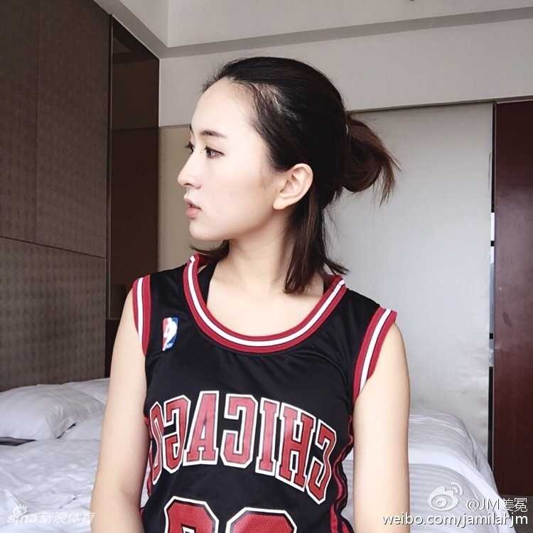 姜冕在街头球场展示球技，篮球稳稳停在她的指尖，背景是模糊的城市光影，这一瞬间定格了她作为街头篮球精灵的酷飒模样