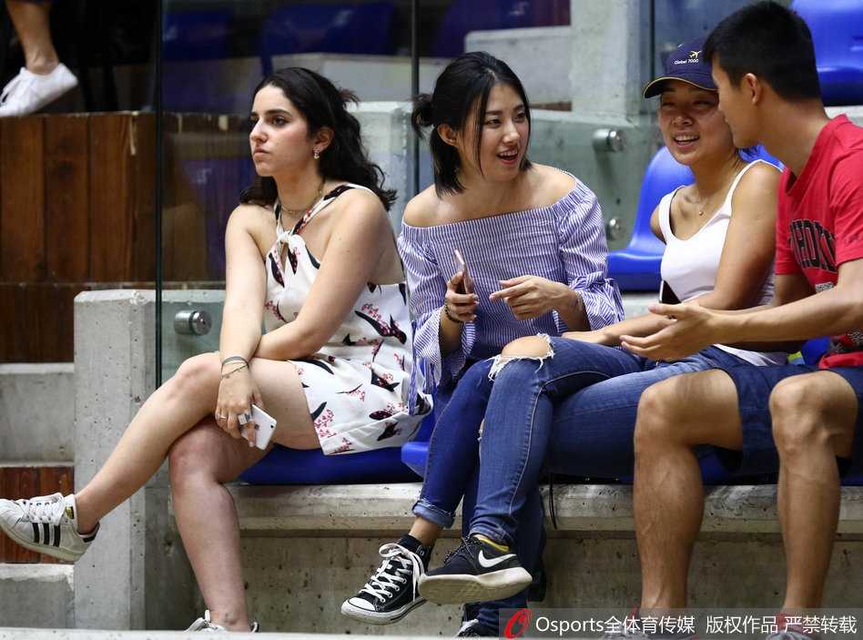 几位球迷在场边热烈交谈，分析着比赛形势，手势丰富，神情投入