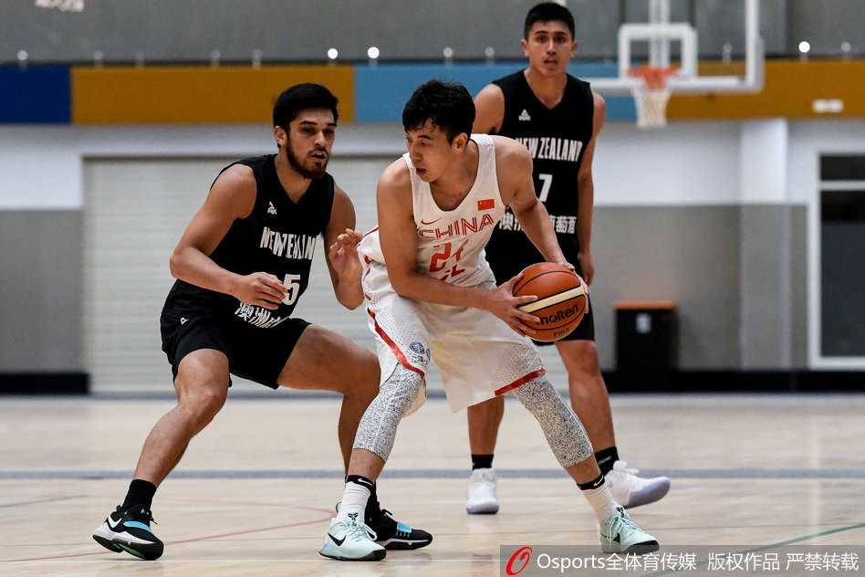 崔晋铭与刘晓宇在三分线外并肩组成防守阵线，两人脚步移动迅速，手臂张开形成屏障，正对新西兰队的持球人实施压迫性的包夹防守。