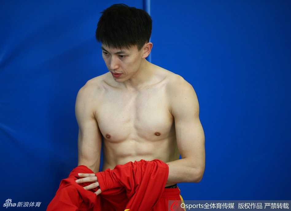 李根赤裸上身展现壮硕肌肉，训练馆灯光下线条分明，犹如钢板雕刻。