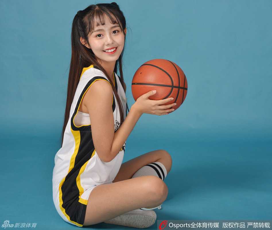 宝贝眼神坚定聚焦赛场，手中花球闪耀如星，仿佛要将这份光芒传递给正在热身的飞虎将士。