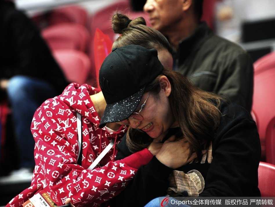 李根妻子在看台上露出甜美笑容，标志性的丸子头干净利落，她手拿手机或许正在记录这一刻，成为激烈比赛之外最温暖的画面。
