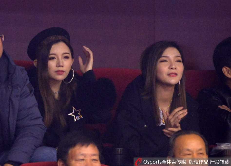 丁彦雨航女友举起手机，记录下球场内的某个瞬间。或许是想拍下爱人罚球时的英姿，又或许是想留住这片红色海洋的喧嚣。闪光灯在她脸上映出微光，也映照出对这场胜利的殷切期盼。