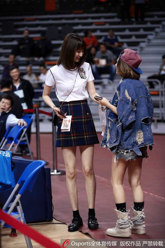 周鹏妻子刘小美在场边用手机录像，记录下丈夫在场上拼搏的珍贵画面，背景是广东队替补席忙碌的教练组，家庭温情与赛场紧张同框定格