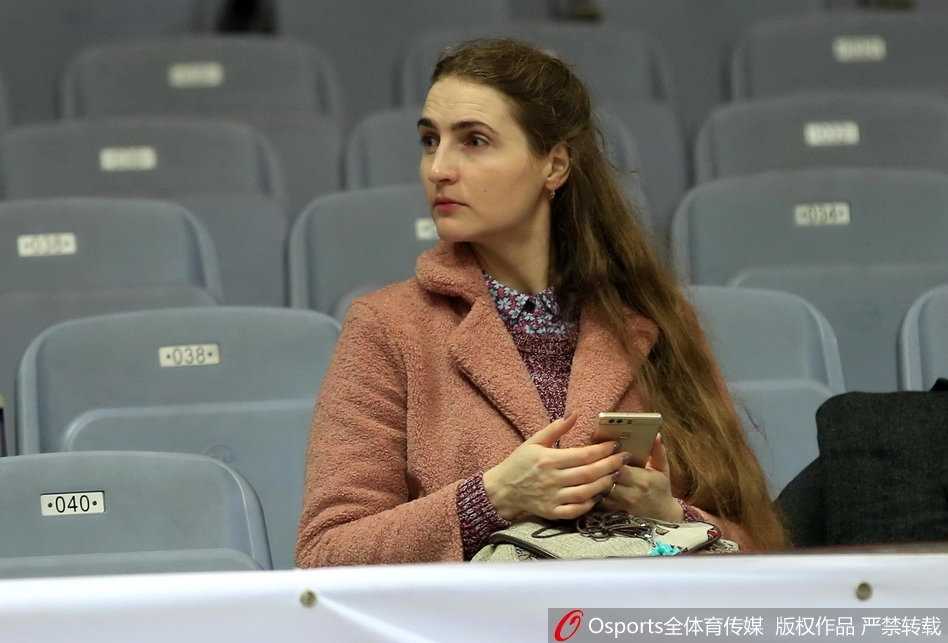 看台上，一位戴着黑框眼镜的清秀女生轻掩朱唇，眼神里写满了对场上局势的紧张与关切，仿佛每一次运球都牵动着她的心跳。