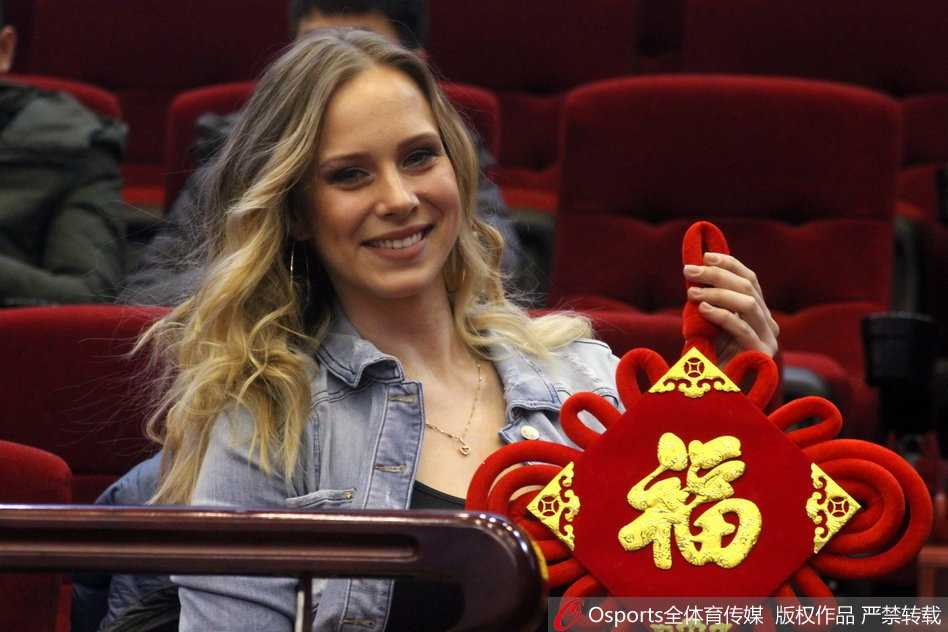 立陶宛冬日的暖阳:莫泰娇妻手执福字,笑靥如花映照齐鲁之心 莫泰尤纳斯的爱妻身披一袭暖冬装扮,双手轻展写有福字的红纸,那灿若星辰的湛蓝眼眸中盛满了对爱人比赛的期许,温婉笑意间流露出东欧女性独有的典雅韵味。