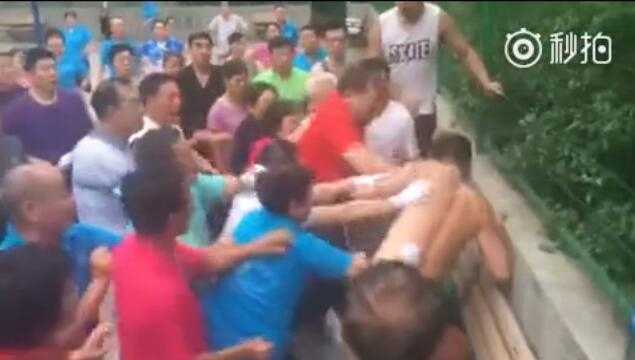 夜幕降临，篮球场上灯火通明，一边是整齐列队的广场舞方阵，另一边是抱着篮球无处可去的年轻人，形成鲜明而无奈的对比。