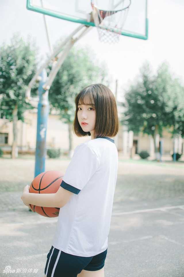 抱着篮球的她，眼神清澈得像夏天的汽水，马尾辫高高束起，球衣下摆随风轻轻摆动
