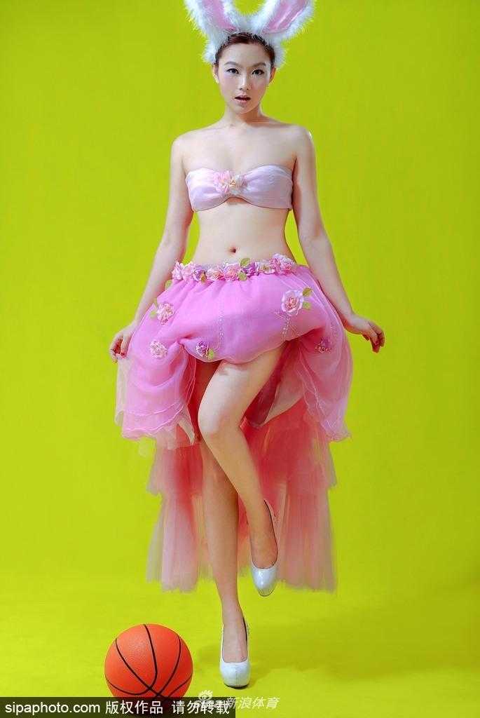 刘闻雯蹲坐在地，手托香腮望向远方，标志性的兔女郎造型在赛场灯光下显得格外耀眼，修长的双腿自然舒展，宛如一幅动感的体育时尚大片。