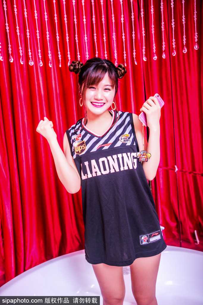 近景特写下，女孩的哪吒头造型精致可爱，专注的眼神和上扬的嘴角，传递出对辽篮最真挚的祝贺与支持。