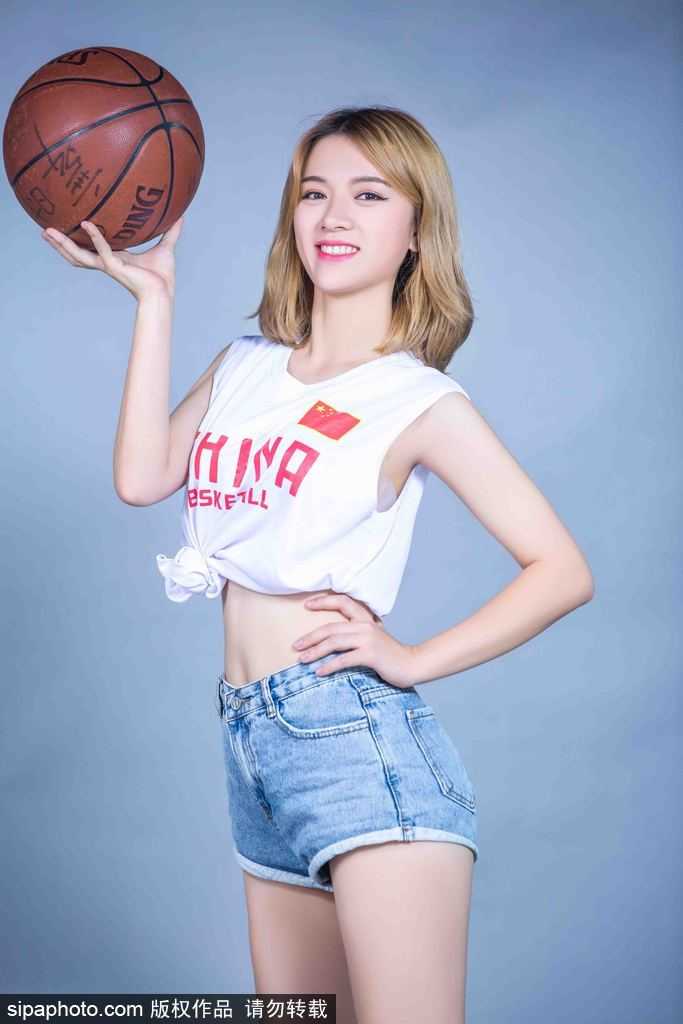 休息间隙，篮球宝贝坐在球场边，随意的坐姿依然难掩修长美腿，她轻轻抚摸着手中的篮球，眼神中流露出对这项运动的深情与热爱，画面温馨而美好。