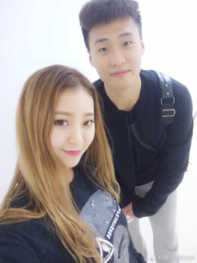 篮球宝贝的追光日记:与宏远众将的“小鸟依人”瞬间 黄逸辉被几位宏远队的小鲜肉环绕在中间,她开心地对着镜头比心,身后是球员们略带青涩的笑容,画面充满活力。