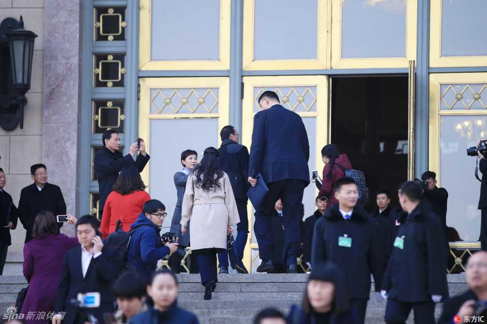 为了准备第二天的大会发言，姚明提前来到人民大会堂调试话筒，工作人员正根据他的身高调整立杆高度