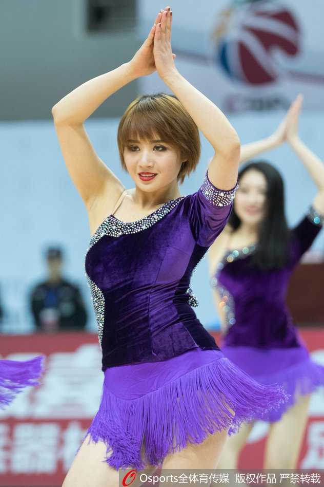 领舞的啦啦队长眼神坚定，高举双手打着节拍，身后的队友们整齐划一，在球队落后的半场时刻用激情感染着每一位观众。