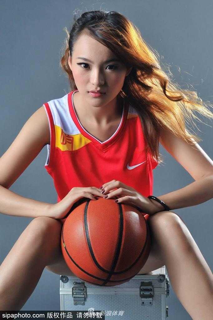 胡晓燕手托篮球，眼神自信，修长美腿在球场上格外耀眼