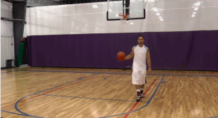 球员在三分线外持球，先是一个小幅度的胯下运球调整节奏，紧接着衔接一个幅度极大的体前变向，球从右手重重拍向左手，身体如猎豹般压低窜出。