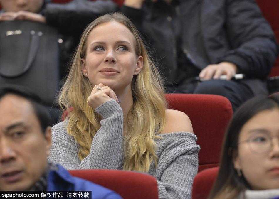 莫泰妻子在看台上专注地观看比赛，双手轻托脸颊，眼神紧紧追随着球场上丈夫的身影，满是关切与骄傲