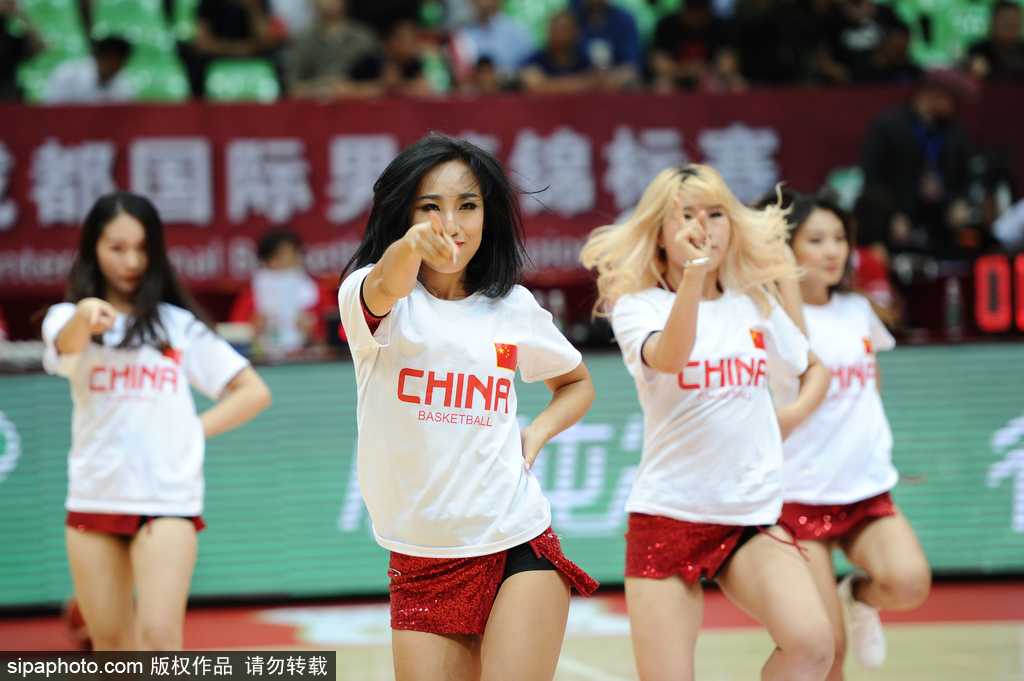 镜头特写捕捉到啦啦队员的迷人微笑，她们手拿炫彩花球，青春气息与场上激烈对抗形成美妙对比。