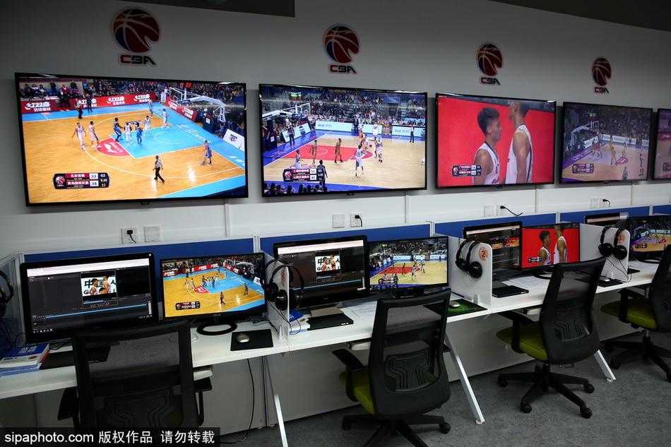 一名回放专员正聚精会神地盯着眼前的多块屏幕，双手熟练地操作着面前的操控台，随时准备截取关键画面。