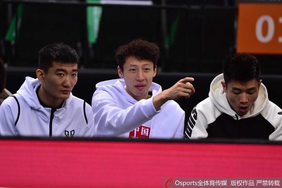 教练组成员在场边神情专注，紧握双拳，目光如炬地盯着场上的局势变化，场边的灯光将他们的身影拉得格外坚定。