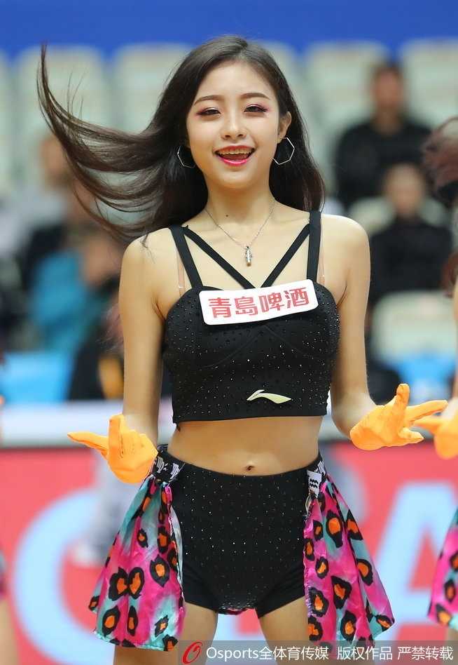 上海篮球宝贝在赛场中央热力开跳，束起的马尾和手中的金色花球随着动感节奏尽情摇摆，灿烂笑容极具感染力