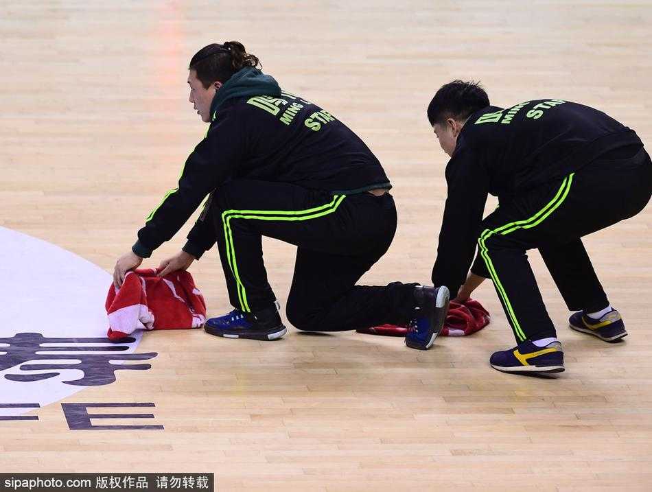 辽宁主场对阵广东比赛中，球员们暂停间隙大汗淋漓，而身穿黄马甲的场地志愿者抓住时机迅速清理地面汗水