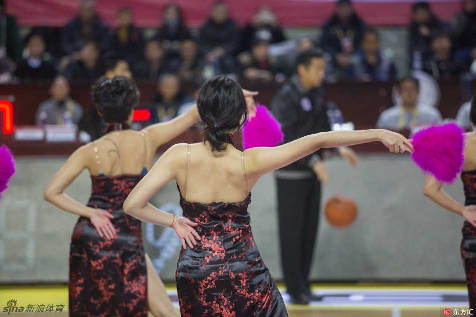 拉拉队员排成纵队，高踢腿动作整齐划一，金色花球在灯光下闪耀，笑容比阳光还灿烂。