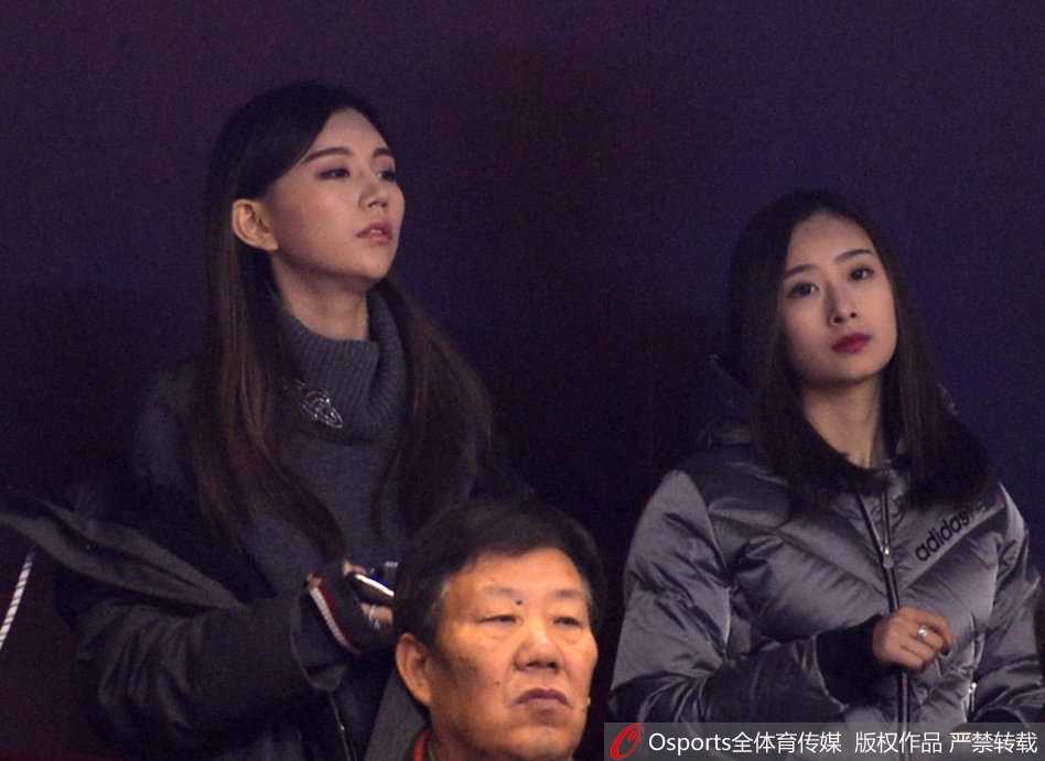 身着黑色时尚外套的丁彦雨航女友，眼神紧锁赛场方向，精致的脸庞上双眉微蹙，仿佛每一次攻防都牵动着她的心弦。