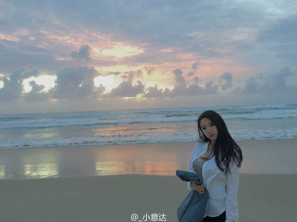 赵岩昊与女友穿着休闲装并肩坐在台阶上，男友视角下的她回眸一笑，长发随风飘动，显得格外温柔动人。