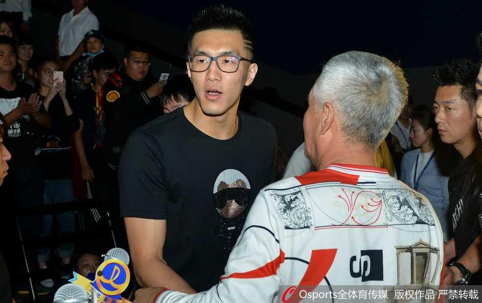 导演大鹏在沈阳首映礼上发言，身旁站着主演乔杉等人，背景是电影海报，现场观众热情高涨