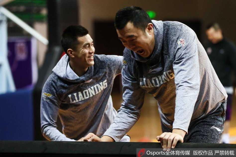 对抗训练结束后，两人并肩坐在场边休息，郭艾伦侧身对着大韩手舞足蹈地讲着什么，韩德君则侧耳倾听，画面充满了兄弟般的信任与温馨