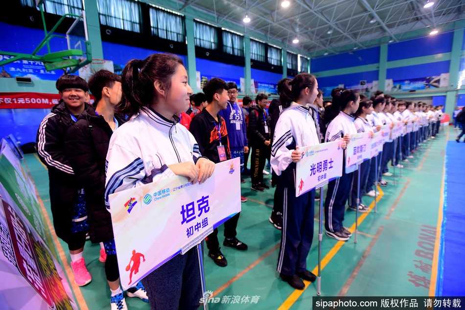 赛场上，身穿深色球衣的高中组球员正侧身突破，他眼神坚毅，面对防守者高高跃起，手中的篮球即将划出一道优美的弧线飞向篮筐。