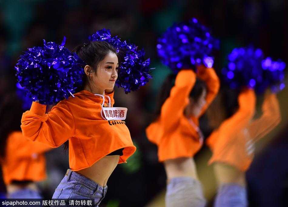 在蓝色的地板上，两名篮球宝贝相视而笑，正在调整舞蹈动作。汗水挂在脸颊上却掩不住眼中的光彩，她们身后的观众席上，是一片模糊却热情的人海。